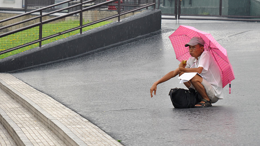 蹲在雨中的大叔 摄影 建智